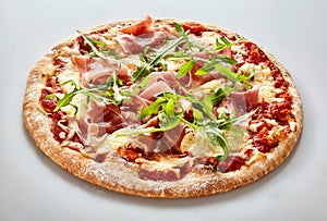 Crusty Italian pizza with ham and rocket photo
