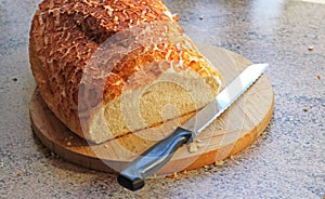 Crusty loaf of bread on wooden board.