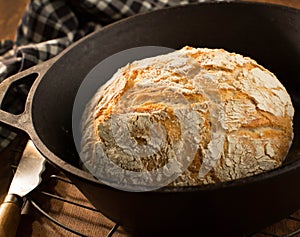 Crusty round loaf of French bread in cast iron dutch oven