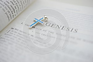 Cruxific close to the word Genesis on the bible photo