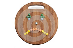 Cry smiley of the round chocolate candies on a wooden board