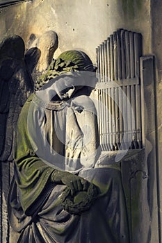 Crying angel organist tombstone on Malostransky cemetery, Prague, Czech republic