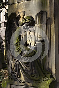 Crying angel organist tombstone on Malostransky cemetery, Prague, Czech republic