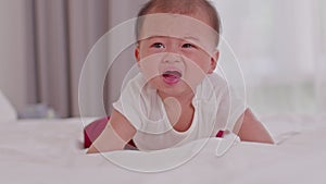 Crying and angry Newborn baby boy lying on white bed at home.Infant baby screaming very hungry or stomach pain.sick asian baby