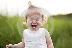 Crying baby alone in the meadow