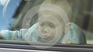 crying baby locked inside car, looking window waiting parents return, violence