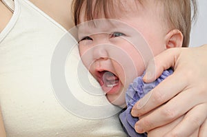 Crying baby at the mother on hands. Soothing upset child embracing and calming