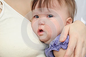 Crying baby at the mother on hands. Soothing upset child embracing and calming