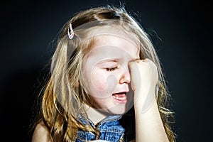 Crying blond little girl with focus on her tears