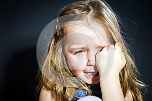 Crying blond little girl with focus on her tears