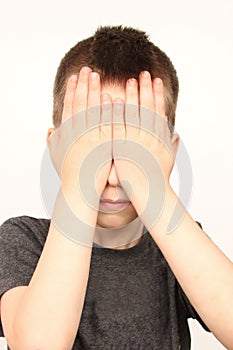 Crying child, kid, covering his eyes with fear, shame or resentment, cry and afraid, concept of abuse, outsider in the childrenâ€™