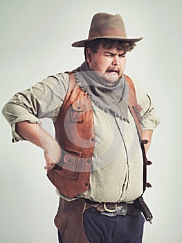 Crying, cowboy and criminal with gun in studio mockup, outlaw and wild west character with pistol. Overweight texas man