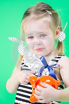 Crying cute little girl with piggy bank