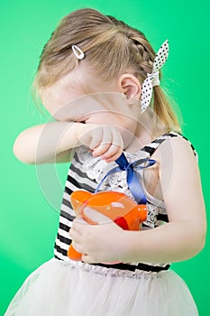 Crying cute little girl with piggy bank