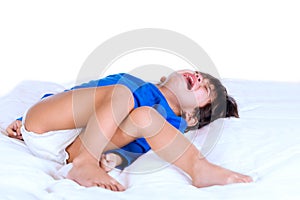 Crying disabled toddler boy lying on white mat