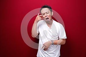 Crying face of Young Asian man with hand gesture. Advertising model concept