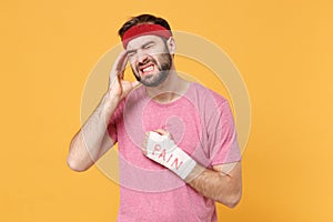 Crying fitness sporty guy 20s sportsman in headband in home gym isolated on yellow background. Workout sport motivation