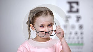 Crying girl taking off glasses, worrying about bullying from peers, insecurities