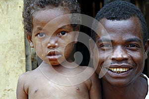 Crying girl with tear on cheek with smiling father - poor africa