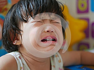 A crying little Asian baby girl with tears