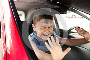 Crying little boy closed inside car