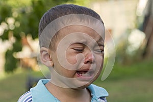 Crying little boy. Cry. Portrait of boy. Caucasian child looks at camera. Charming boy the kid cries with tears in his eyes. an