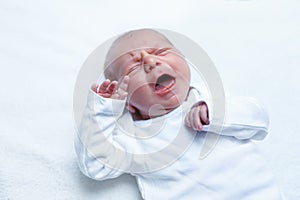 Crying newborn baby boy or girl on changing table