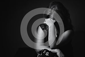 Crying sad woman on a black background