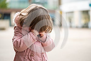 Crying toddler baby girl, outside portrait, soft focus, spring time, copy space