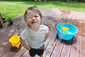 Crying toddler boy playing with water