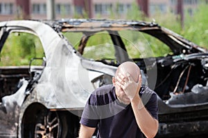 Crying upset man at arson fire burnt car vehicle junk