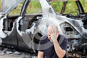 Crying upset man at arson fire burnt car vehicle junk