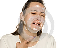 Crying woman applying face cream