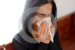 Crying woman blowing nose with wipe at funeral day