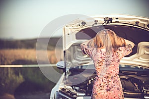 Crying woman in front of a broken car waiting for roadside assistance. Copy space