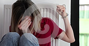 Crying woman is handcuffed to a radiator