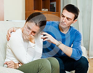 Crying woman has problem, man consoling her photo