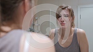 Crying woman in mirror looking at herself, weeping