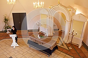 Crying woman near coffin at funeral in church