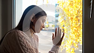 Crying woman touching window, felling sorrow and frustration, autumn depression