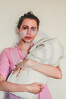 Crying young mother holds her baby on white background. Concept of postpartum depression