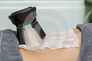 Cryolipolysis freeze fat procedure in cosmetic salon, belly close-up