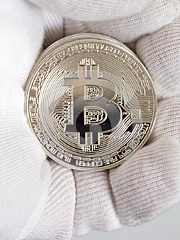 Crypto currency bitcoin on hand in white glove