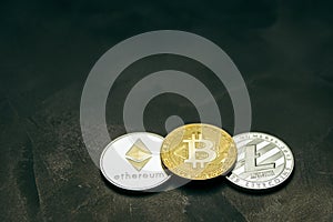 Crypto currency: bitcoin litecoin and ethereum on background from decorative plaster