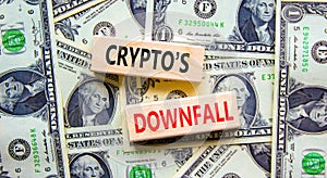 Crypto downfall symbol. Concept words Cryptos downfall on wooden blocks. Beautiful background from dollar bills. Business and