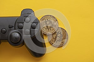 Crypto gaming concept. Video game controller with a bitcoin cryptocurrency coin