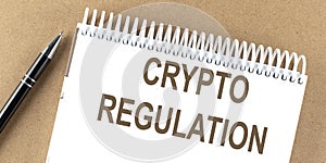 CRYPTO REGULATION text on a notepad with pen, business