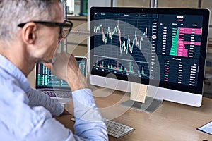 Crypto trader investor analyst looking at computer analyzing data on pc monitor.