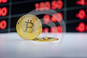 Cryptocurrency Bitcoin currency with finance diagram blurred in the background