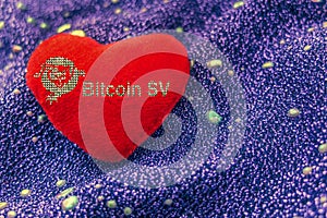 The cryptocurrency Bitcoin SV symbol is a red plush heart with a neon background. bsv